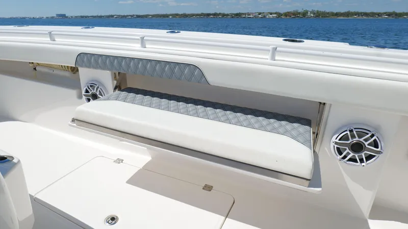 Slide: The Image of Invincible 37 Catamaran 2020 with cushioned seating and speakers, overlooking the ocean. - 38