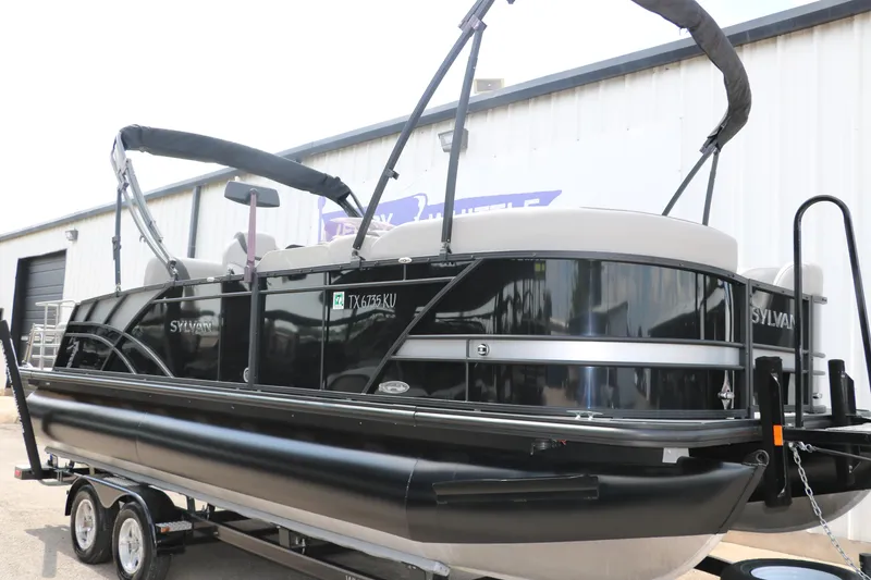 Slide: The Image of 2022 Sylvan L3 RLZ pontoon boat on trailer, parked outside a building. - 5