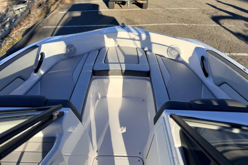 Slide: The Image of 2025 Yamaha Boats AR190 interior with seating and speakers, parked on pavement. - 24