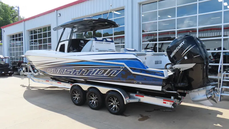 Slide: The Image of 2017 Sunsation 32 CCX boat with Mercury engines on a trailer outside a showroom. - 2
