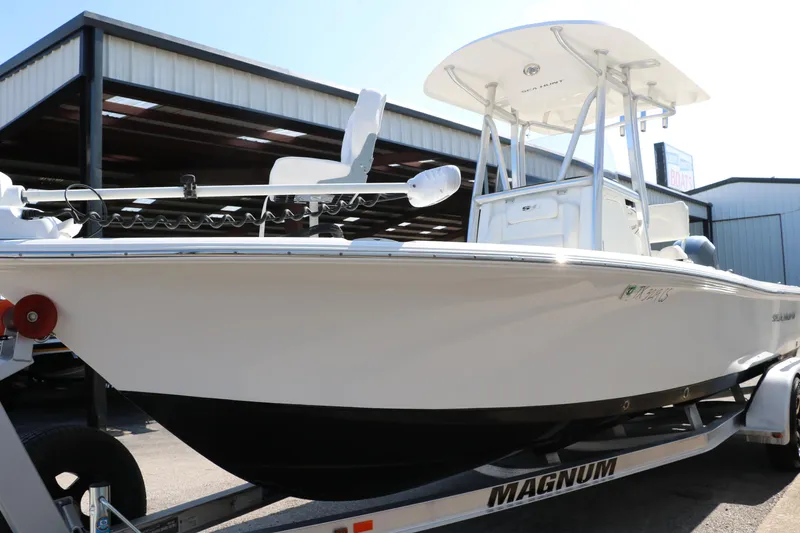 Slide: The Image of 2015 Sea Hunt BX22BR boat on trailer, parked near a metal building. - 13