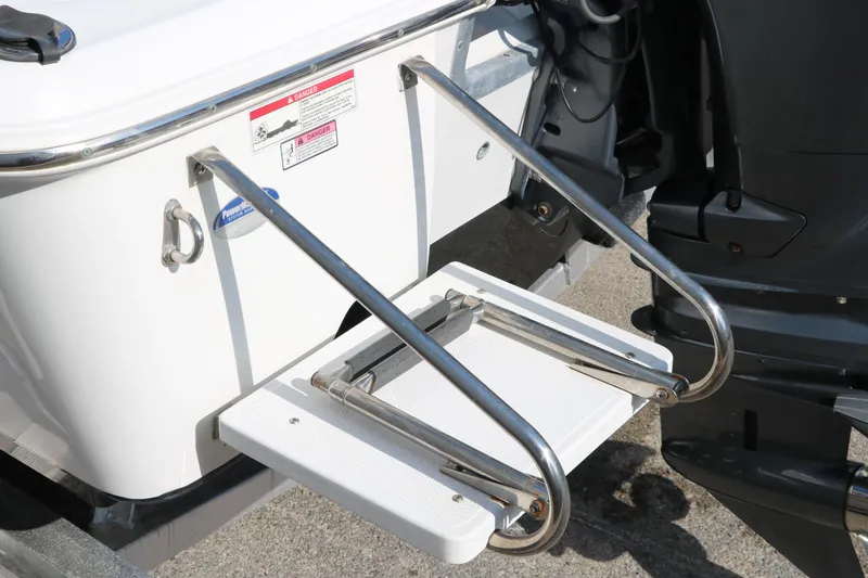 Slide: The Image of 2015 Sea Hunt BX22BR boat with stainless steel swim ladder and outboard motor. - 15