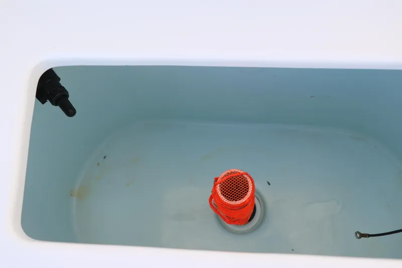 Slide: The Image of Livewell interior of 2015 Sea Hunt BX22BR boat, featuring a drain and orange filter. - 22