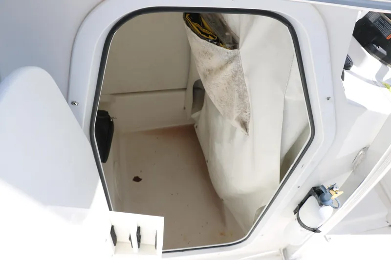 Slide: The Image of 2015 Sea Hunt BX22BR boat storage compartment with white interior and fabric pocket. - 24