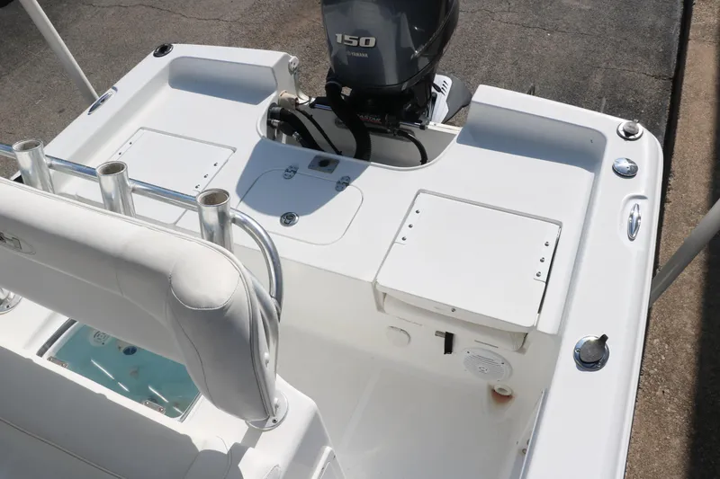 Slide: The Image of 2015 Sea Hunt BX22BR boat deck with Yamaha 150 engine, rod holders, and storage compartments. - 26
