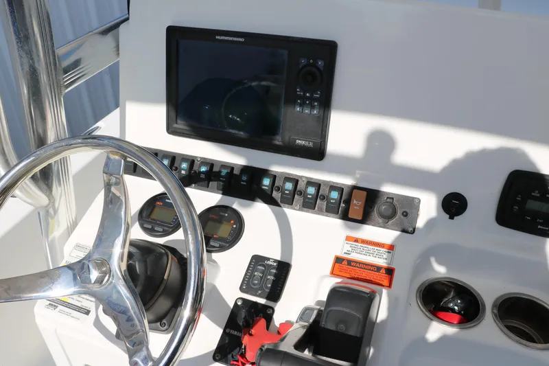Slide: The Image of 2015 Sea Hunt BX22BR boat dashboard with steering wheel and navigation controls. - 29