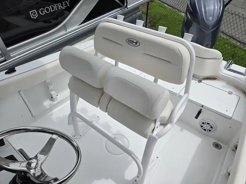 Slide: The Image of 2025 Sea Hunt Ultra 219 boat interior with white cushioned seating and steering wheel. - 10