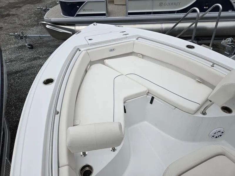 Slide: The Image of 2025 Sea Hunt Ultra 219 boat interior with white cushioned seating and cup holders. - 13