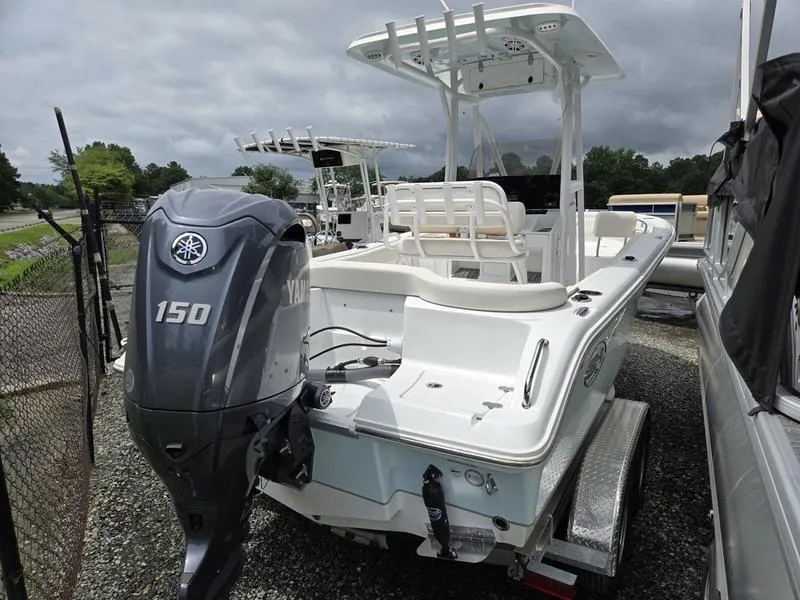 Slide: The Image of 2025 Sea Hunt Ultra 219 boat with Yamaha 150 engine, parked on a trailer. - 2