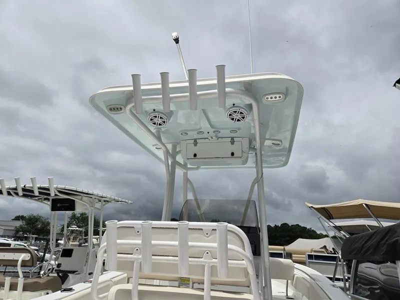 Slide: The Image of 2025 Sea Hunt Ultra 219 boat with T-top and rod holders under cloudy sky. - 3