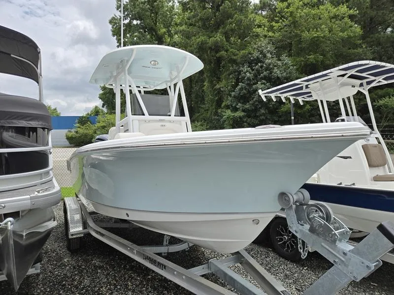 Slide: The Image of 2025 Sea Hunt Ultra 219 boat on trailer, surrounded by trees and other boats. - 4
