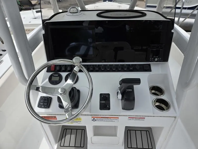 Slide: The Image of Control console of 2025 Sea Hunt Ultra 219 boat with steering wheel and navigation controls. - 7