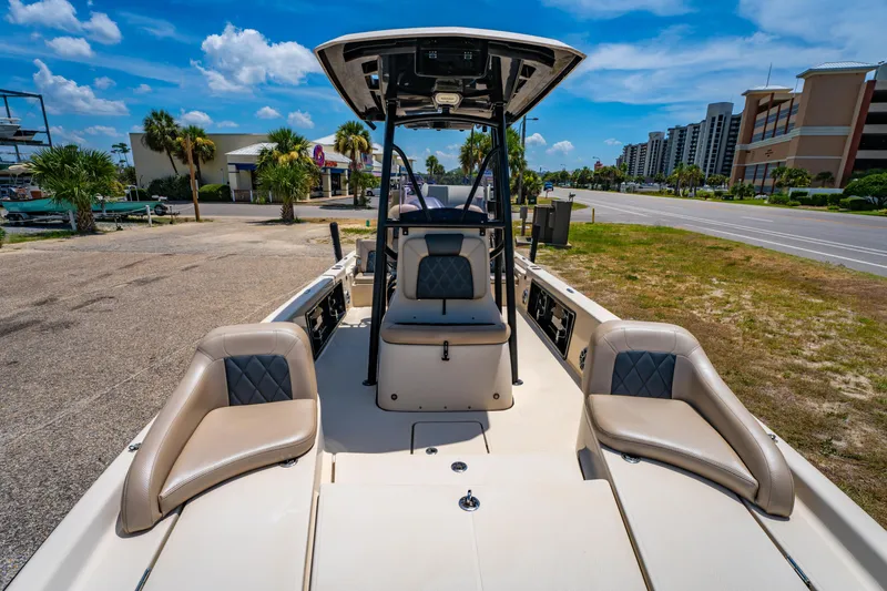 Slide: The Image of 2020 Blue Wave 2400 PureBay boat interior with seating, parked near a road and buildings. - 10