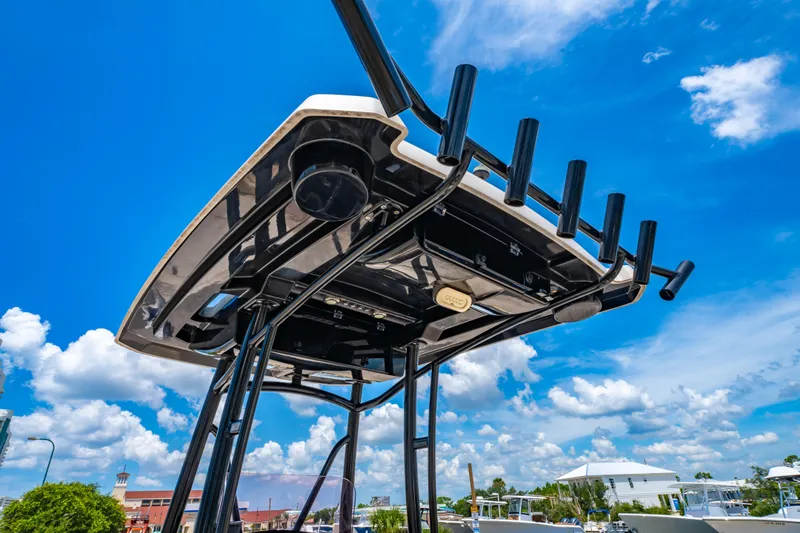 Slide: The Image of 2020 Blue Wave 2400 PureBay boat with rod holders against a clear blue sky. - 12