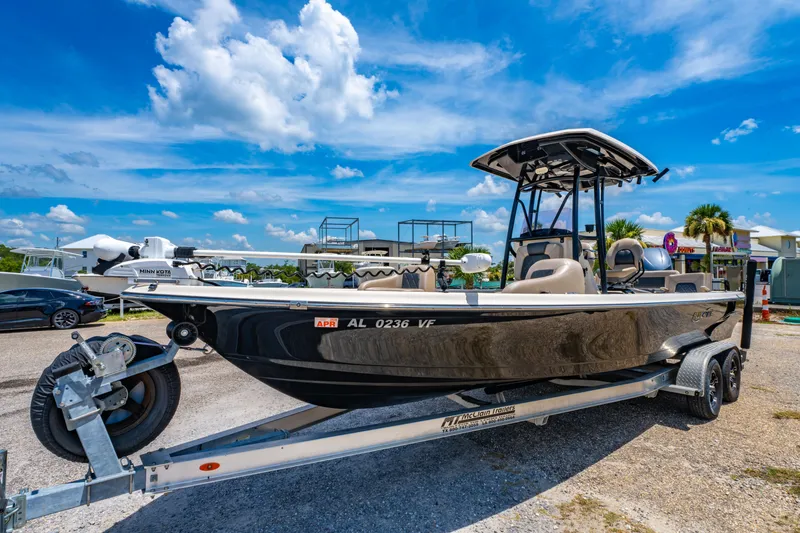Slide: The Image of 2020 Blue Wave 2400 PureBay boat on trailer under a bright blue sky. - 2