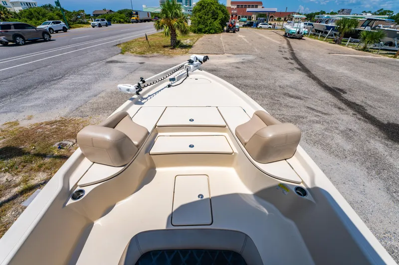Slide: The Image of 2020 Blue Wave 2400 PureBay boat interior with seating and storage, parked near a road. - 20