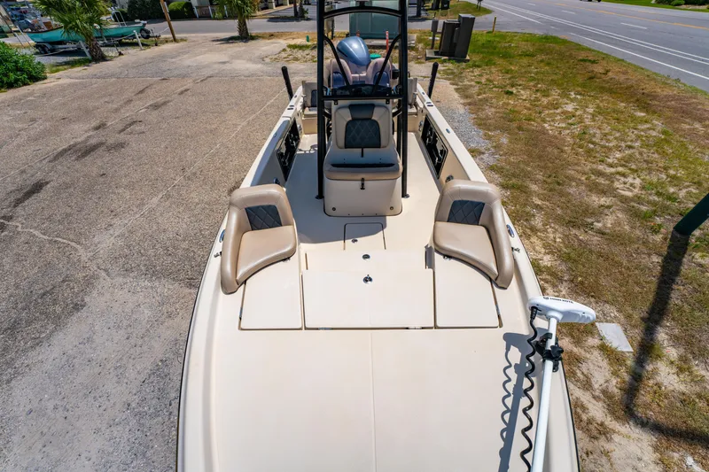Slide: The Image of 2020 Blue Wave 2400 PureBay boat with seating and trolling motor, parked on a sunny day. - 24