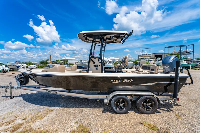Slide: The Image of 2020 Blue Wave 2400 PureBay boat on trailer under clear blue sky. - 4