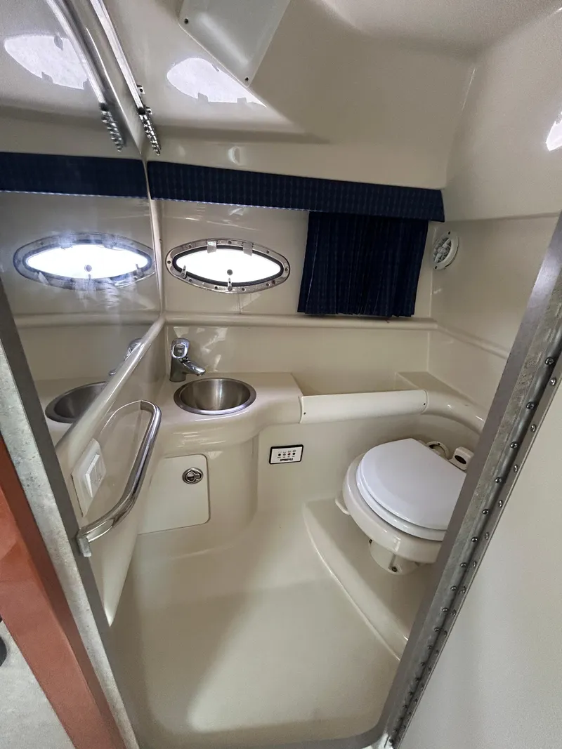 Slide: The Image of 2007 Formula 330 Sun Sport boat bathroom with sink, toilet, and porthole windows. - 12