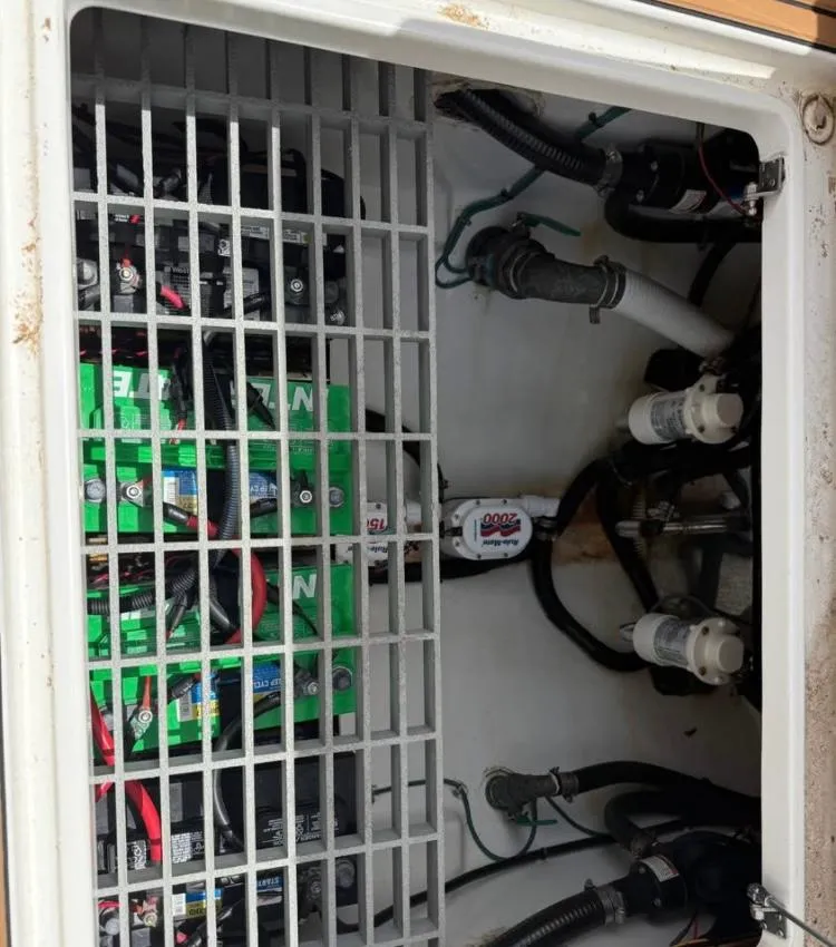 Slide: The Image of Electrical compartment of a 2022 Sea Pro 320 DLX Offshore boat, showing batteries and wiring. - 10