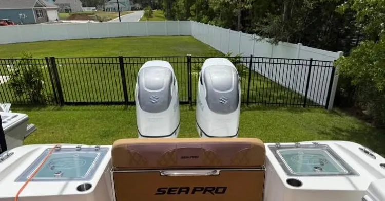 Slide: The Image of 2022 Sea Pro 320 DLX Offshore boat with dual engines, parked in a grassy yard. - 4