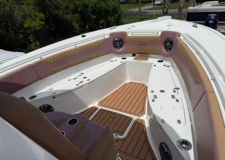 Slide: The Image of 2022 Sea Pro 320 DLX Offshore boat interior with cushioned seating and teak flooring. - 7