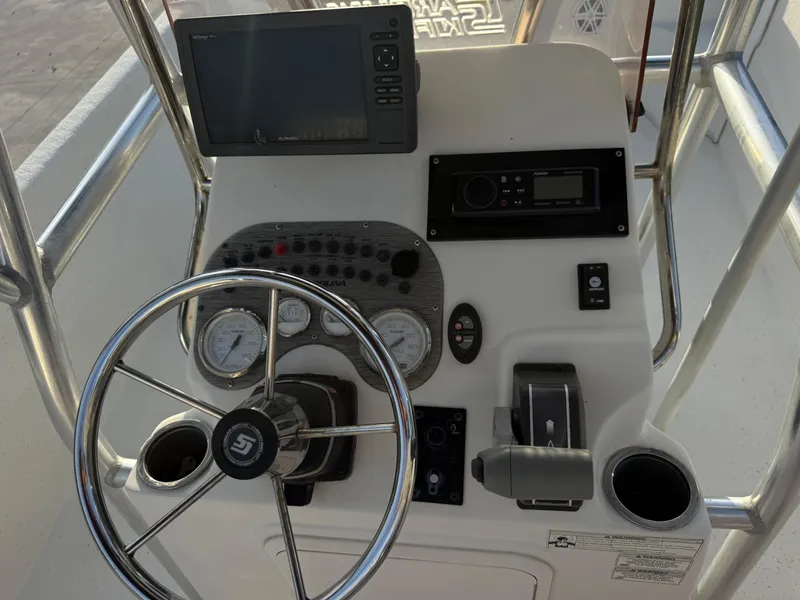 Slide: The Image of 2016 Carolina Skiff 238DLV boat console with steering wheel and navigation controls. - 21