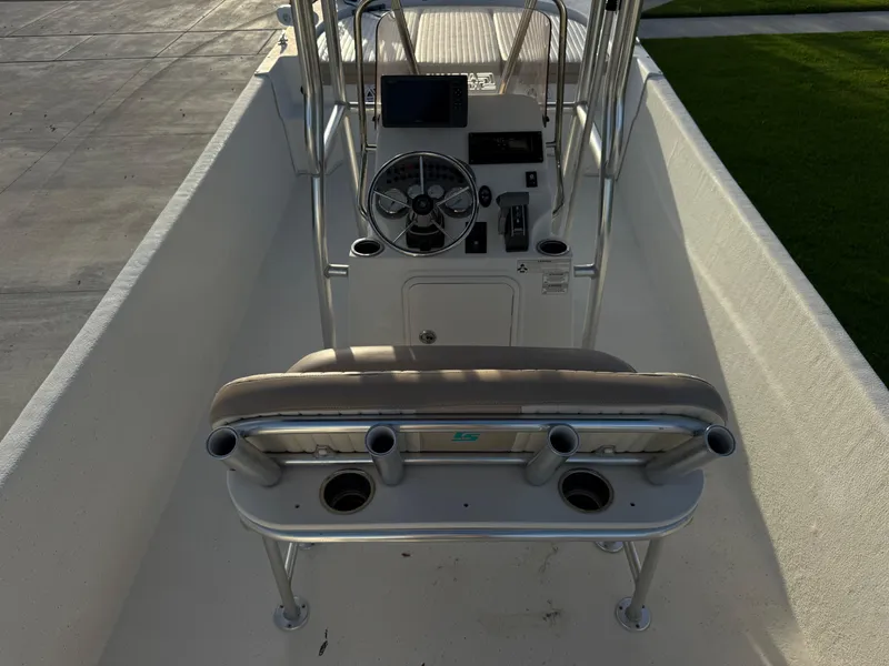 Slide: The Image of 2016 Carolina Skiff 238DLV boat interior with steering console and rod holders. - 22
