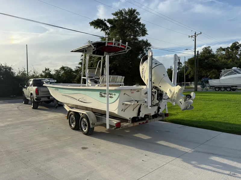 Slide: The Image of 2016 Carolina Skiff 238DLV boat on trailer, parked beside a truck in a driveway. - 3