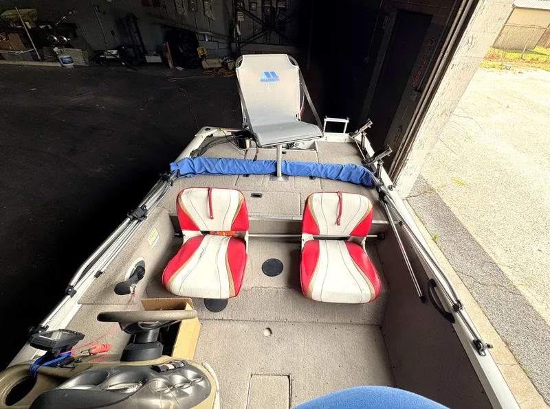 Slide: The Image of 2004 Lowe 170W boat interior with red and white seats, steering console, and fishing gear. - 10