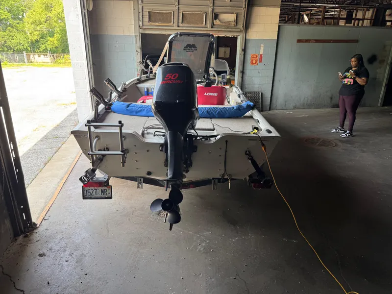 Slide: The Image of 2004 Lowe 170W boat with Mercury engine in a garage setting. - 12