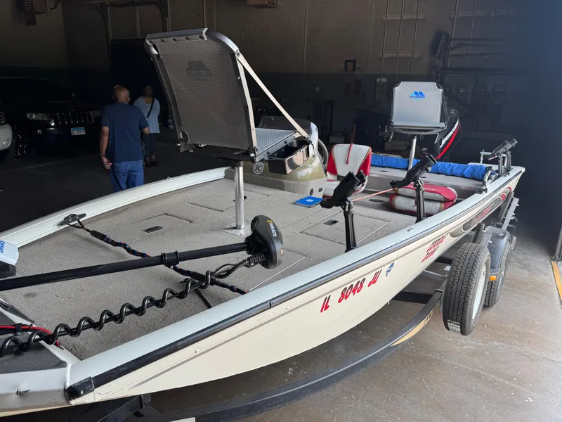 Slide: The Image of 2004 Lowe 170W fishing boat in garage, equipped with seats and motor. - 16