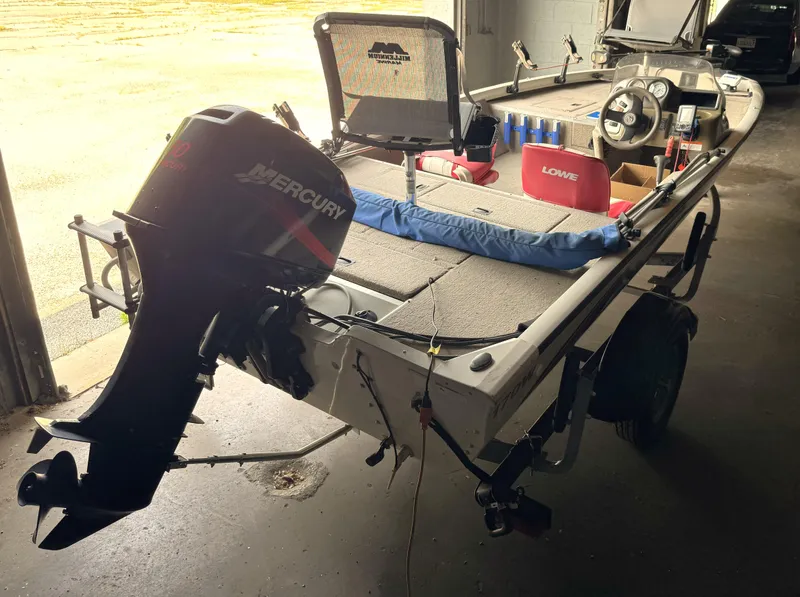 Slide: The Image of 2004 Lowe 170W boat with Mercury outboard motor in a garage setting. - 18