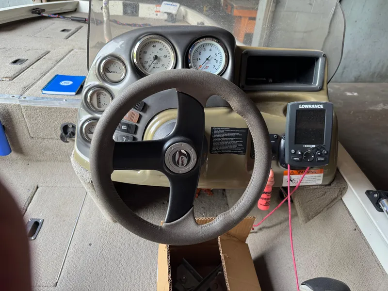 Slide: The Image of Steering console of a 2004 Lowe 170W boat with gauges and Lowrance fish finder. - 3