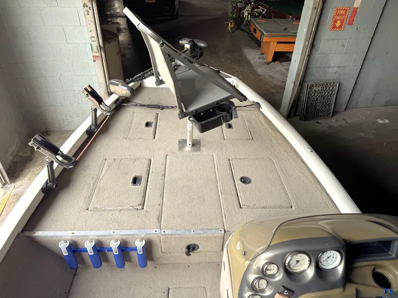 Slide: The Image of 2004 Lowe 170W boat interior with fishing rod holders and control panel in a garage. - 4