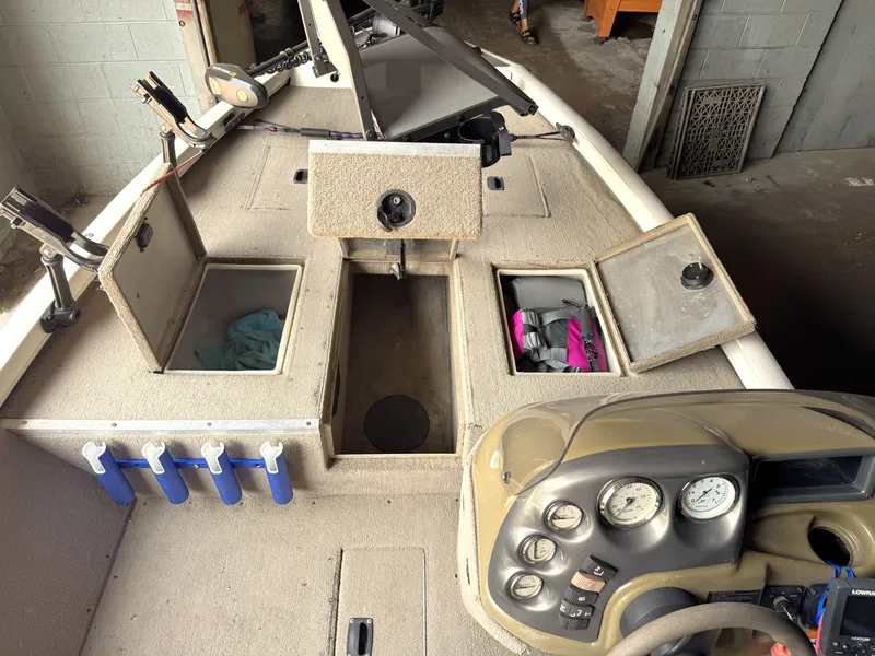 Slide: The Image of 2004 Lowe 170W boat interior with storage compartments and control panel. - 5