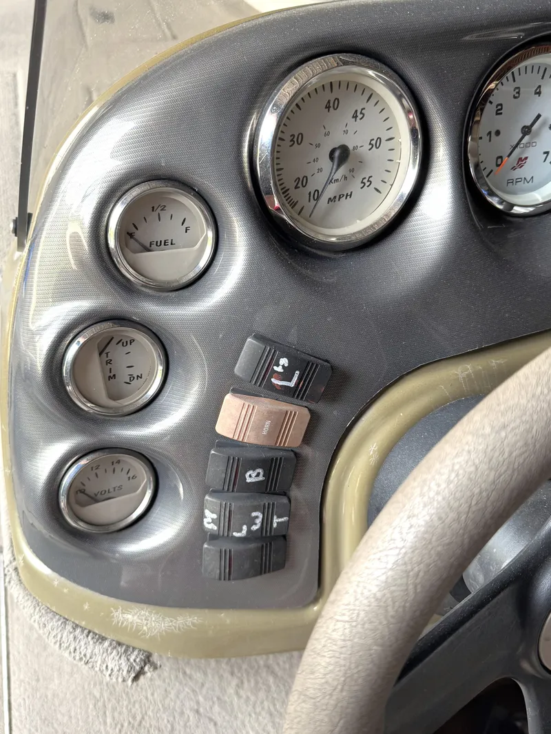 Slide: The Image of Dashboard of a 2004 Lowe 170W boat with gauges and switches. - 6
