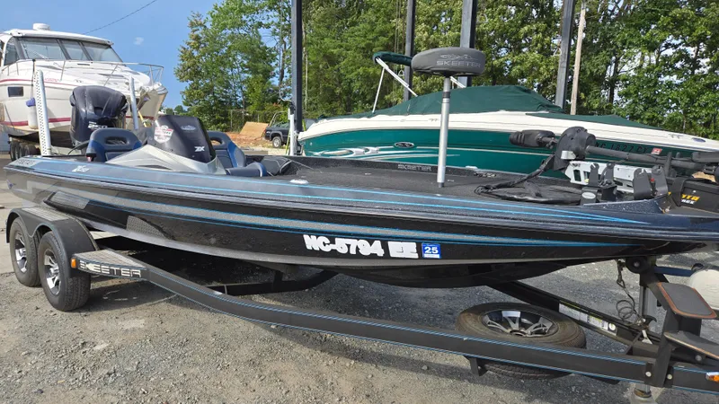 Slide: The Image of 2017 Skeeter ZX 250 boat on trailer, parked outdoors near other boats. - 1