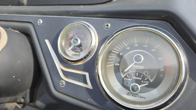Slide: The Image of Close-up of 2017 Skeeter ZX 250 boat dashboard gauges showing RPM and trim indicators. - 25