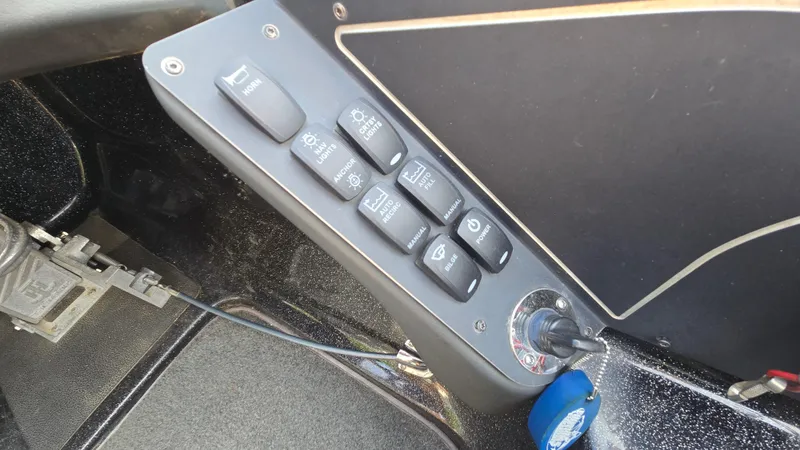 Slide: The Image of Control panel of a 2017 Skeeter ZX 250 boat with various switches and ignition key. - 28