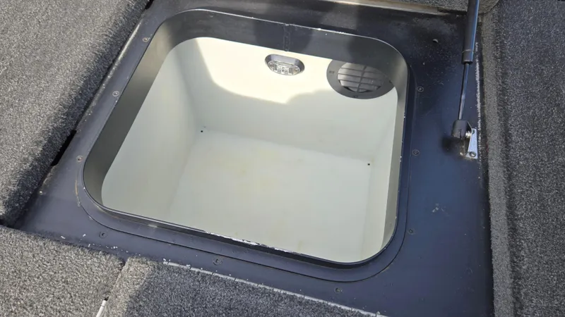 Slide: The Image of 2017 Skeeter ZX 250 boat storage compartment, open and empty, with carpeted edges. - 34