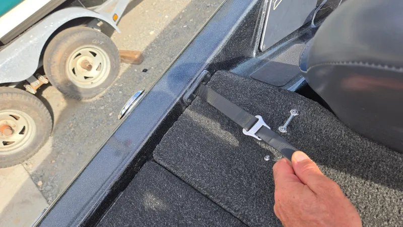 Slide: The Image of Hand securing strap on 2017 Skeeter ZX 250 boat deck, trailer visible in background. - 37