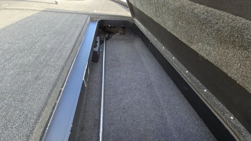 Slide: The Image of 2017 Skeeter ZX 250 boat storage compartment with carpeted interior and metal rod. - 41