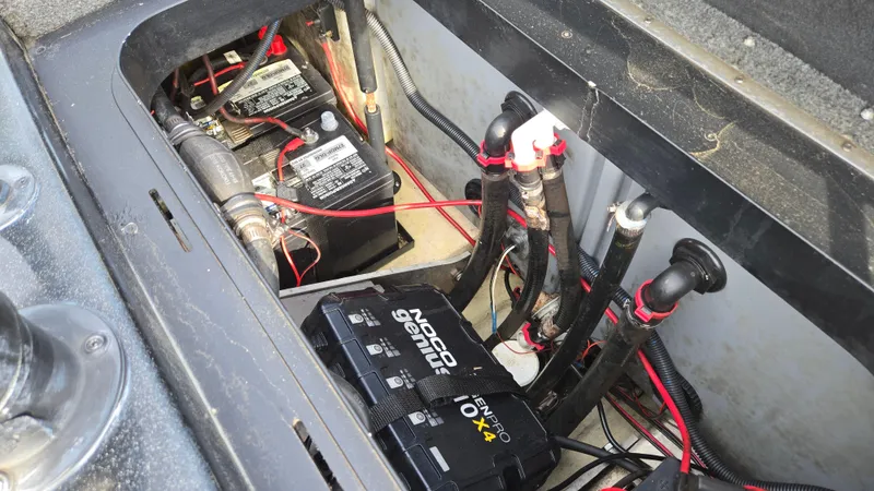 Slide: The Image of 2017 Skeeter ZX 250 boat battery compartment with wiring and charger. - 49