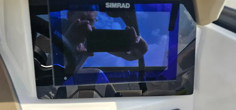 Slide: The Image of Simrad display on 2025 Heyday H22 boat dashboard, reflecting sky and person. - 14