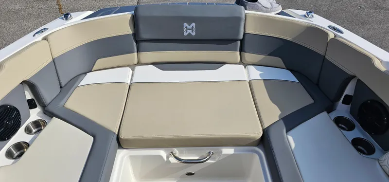 Slide: The Image of 2025 Heyday H22 boat interior with beige and gray seating, cup holders, and speaker system. - 4