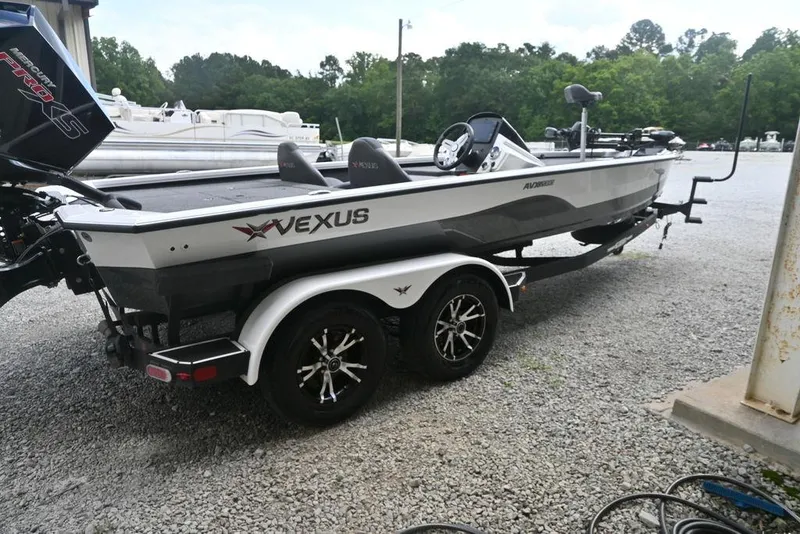 Slide: The Image of 2021 Vexus AVX2080 boat on trailer, parked on gravel, with trees in background. - 3