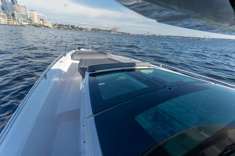 Slide: The Image of 2021 Axopar 37XC Aft Cabin cruising on open water near city skyline. - 15