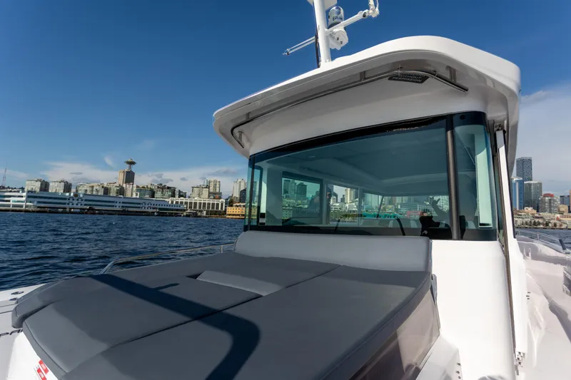 Slide: The Image of 2021 Axopar 37XC Aft Cabin boat with city skyline in the background. - 17