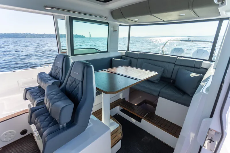 Slide: The Image of Interior of 2021 Axopar 37XC Aft Cabin with seating and table, overlooking the ocean. - 20